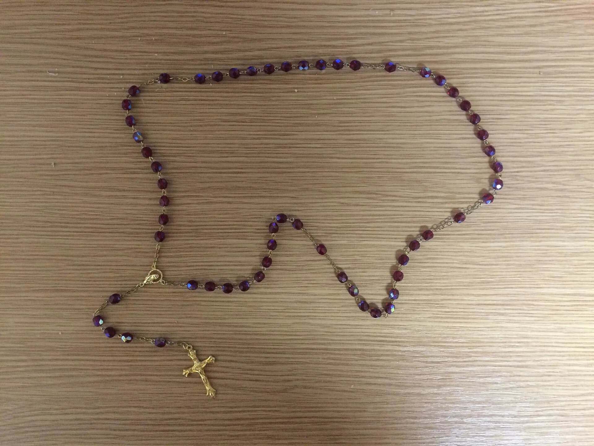 Terço de contas facetadas roxas com corrente e crucifixo metálicos