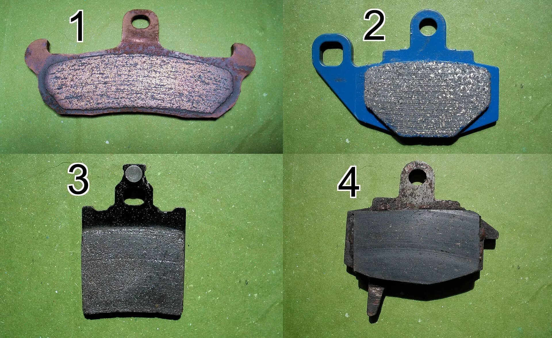 Quatro pastilhas de freio automotivas sobre fundo verde