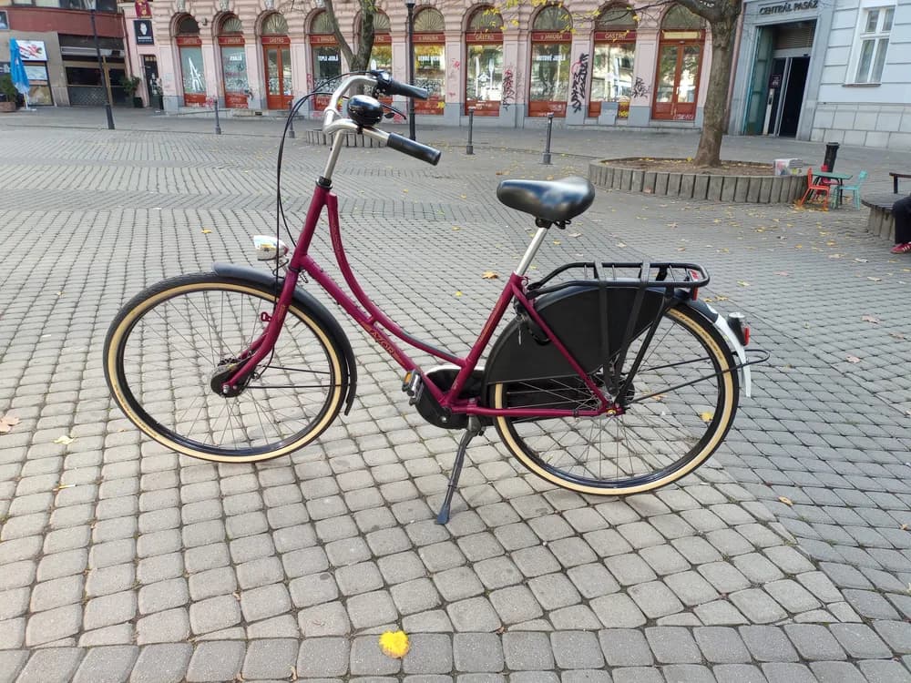 Bicicleta de passeio vermelha com bagageiro em praça