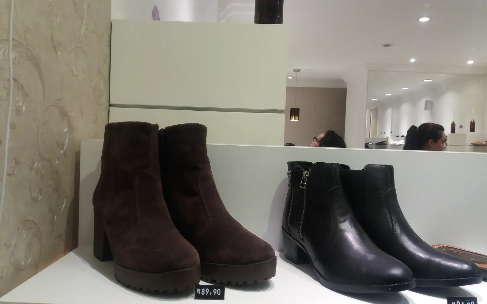 Vitrine atual de uma loja de calçados em Franca, São Paulo, com botas expostas