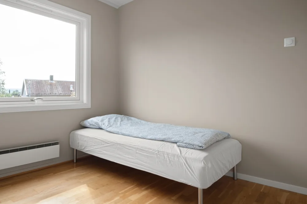 Cama de solteiro com colchão em quarto residencial neutro