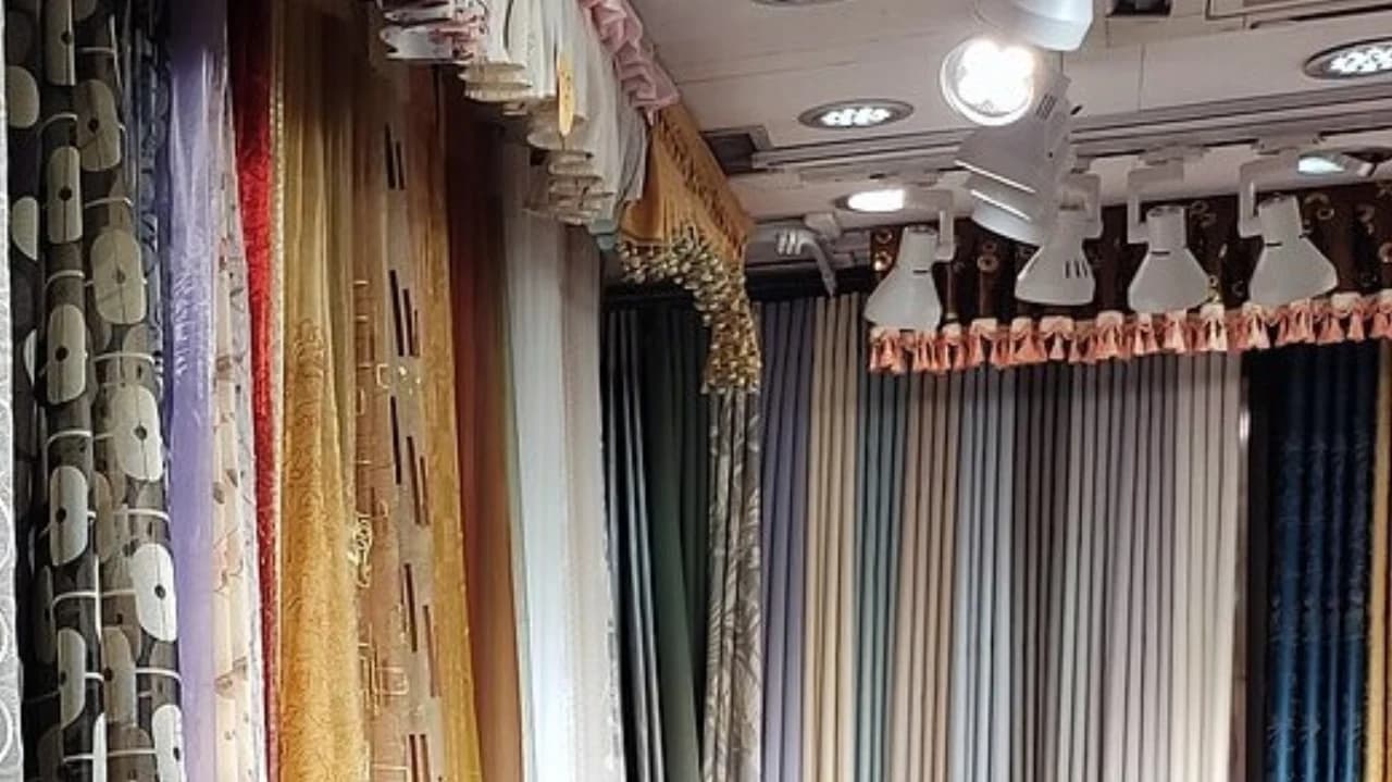 Mostruário comercial com várias cortinas expostas lado a lado em uma loja
