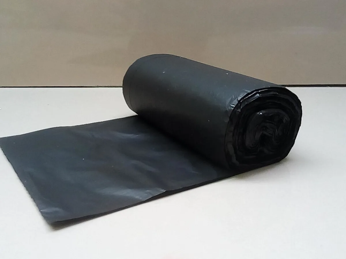 Rolo de sacos pretos para lixo sobre uma superfície clara