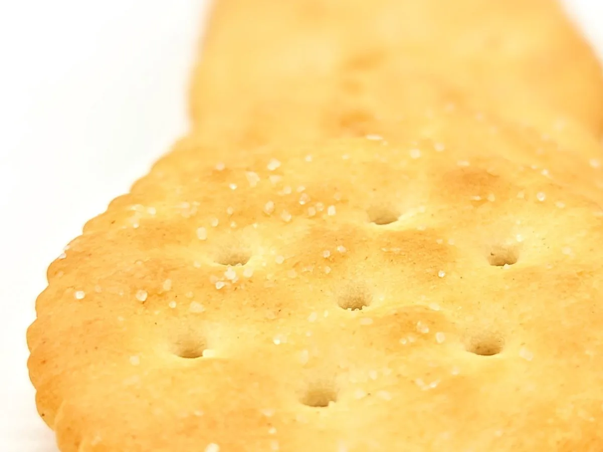 Biscoitos salgados redondos empilhados sobre fundo branco