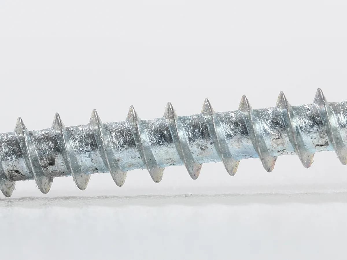 Close de um parafuso metalico para madeira com rosca e cabeca escareada