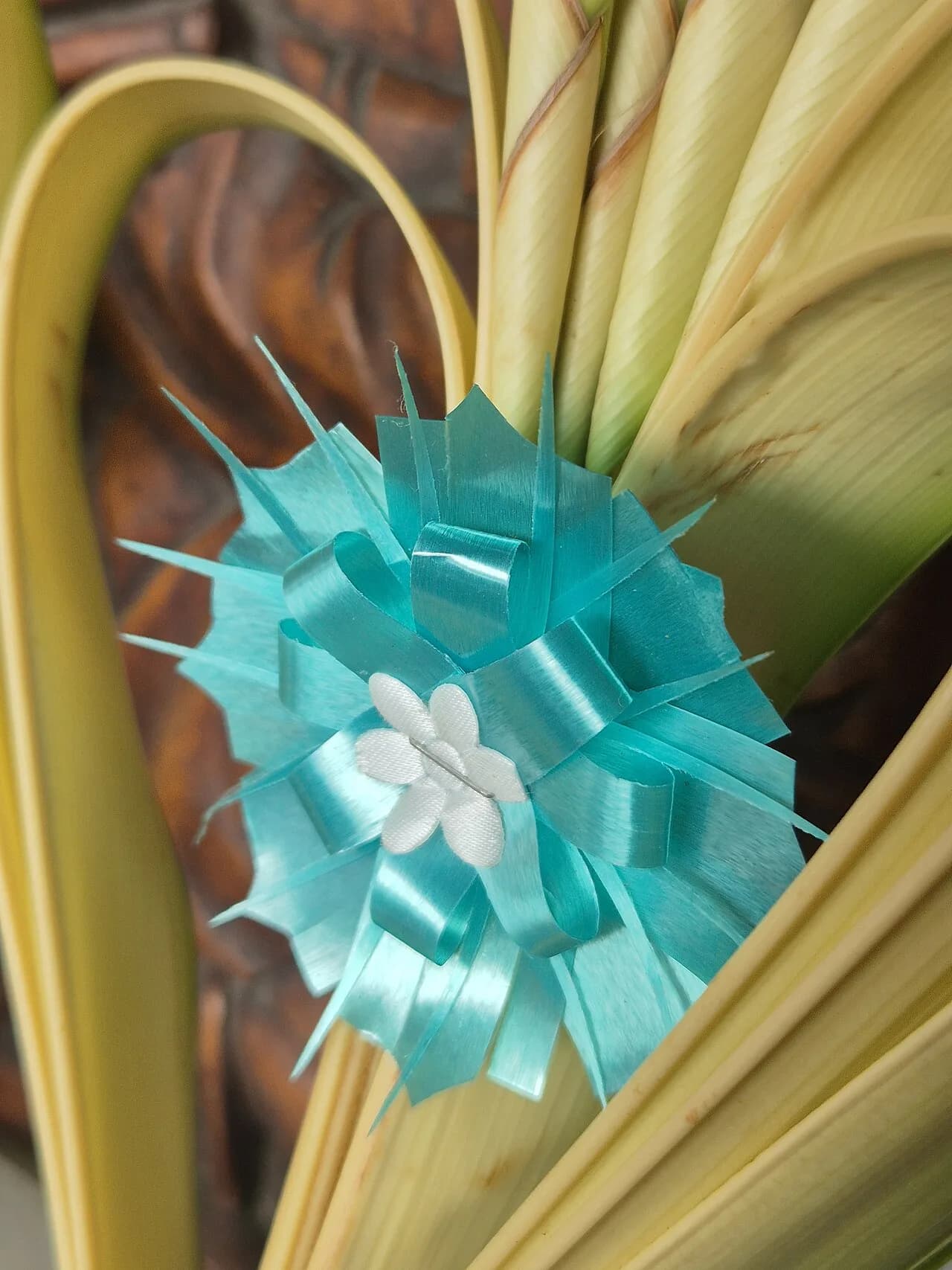 Enfeite decorativo em forma de flor feito com fita plástica