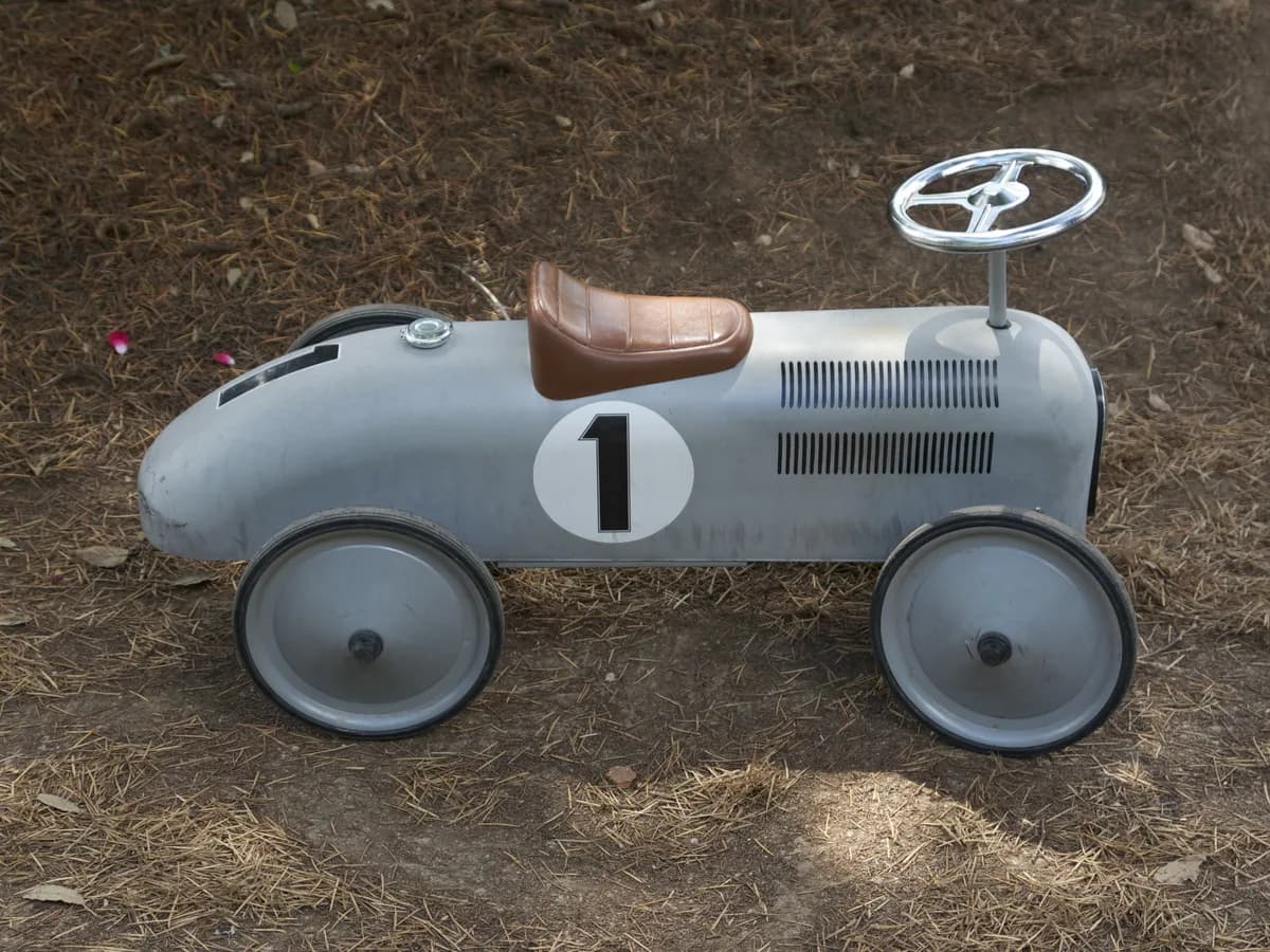 Carrinho de brinquedo cinza exposto em uma superfície externa