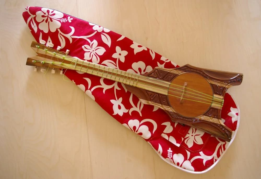Ukulele de madeira sobre uma capa estampada vermelha
