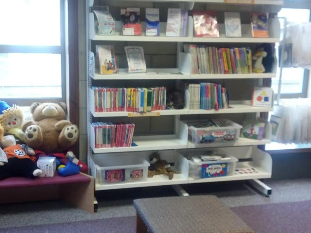 Estante com livros infantis coloridos e brinquedos de leitura