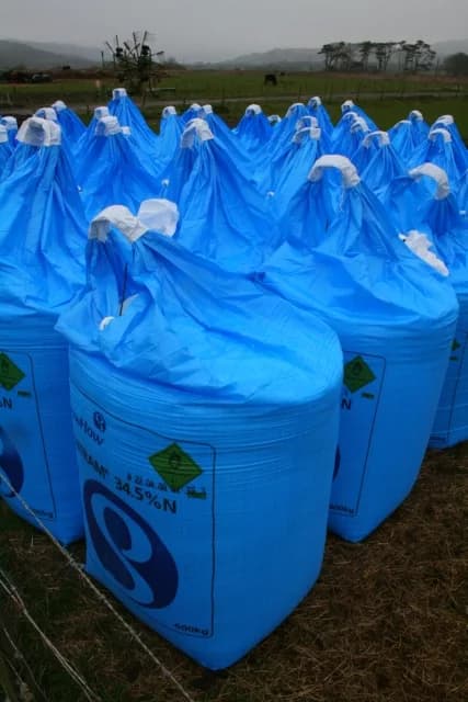 Sacaria de insumos agrícolas organizada em uma área rural