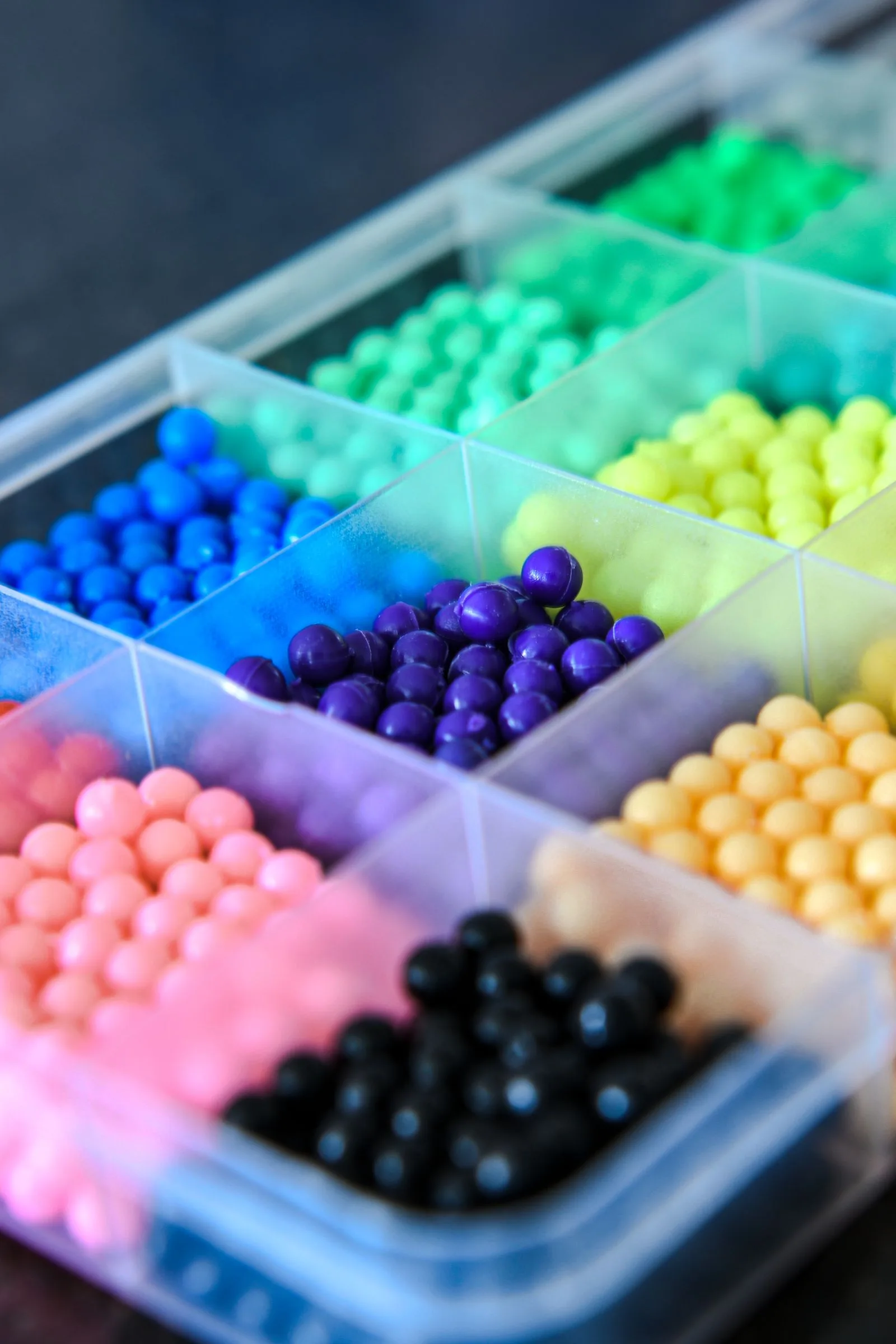Miçangas coloridas separadas em compartimentos de um organizador
