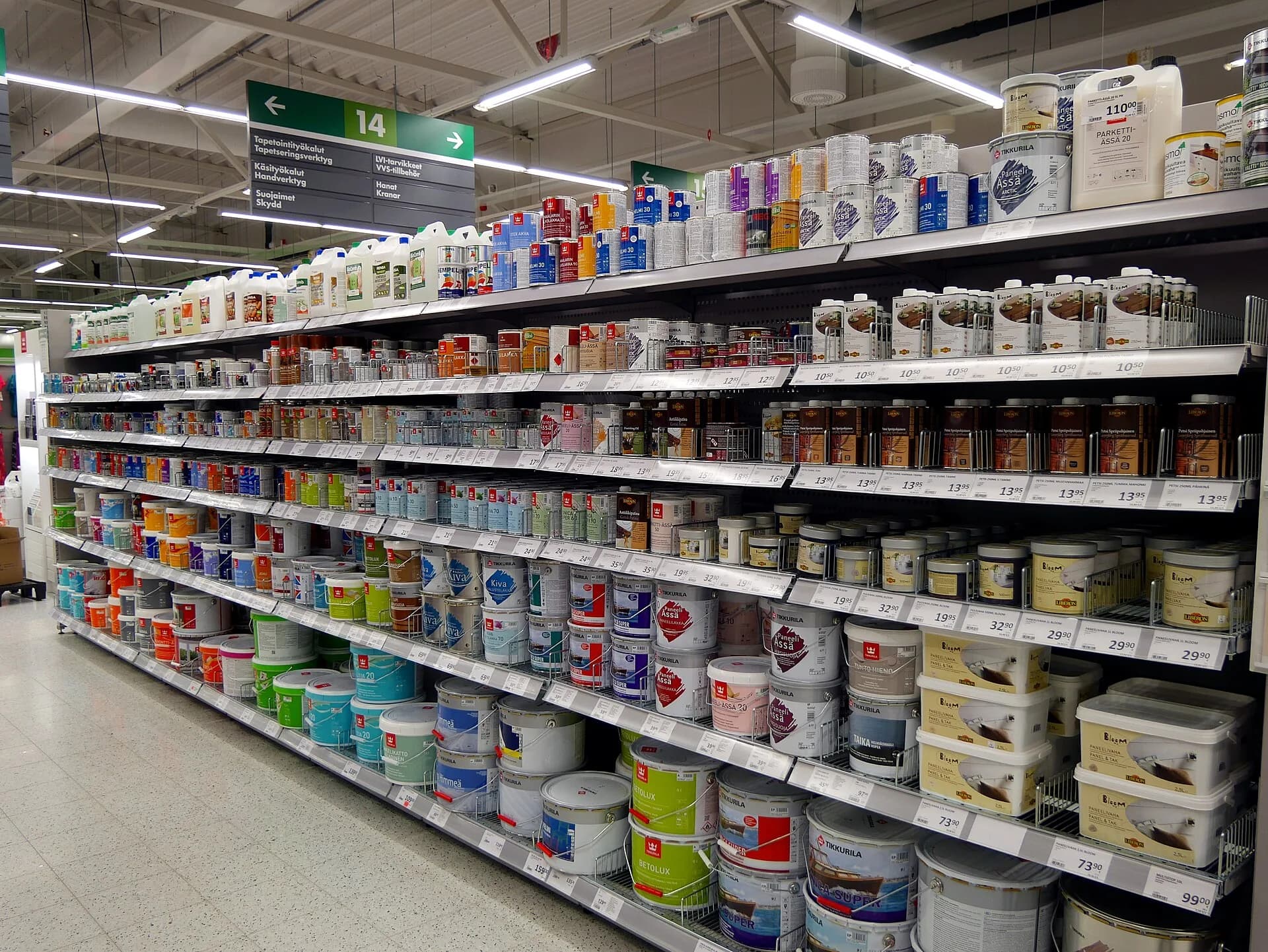 Latas e baldes de tinta de construção organizados em corredor de loja