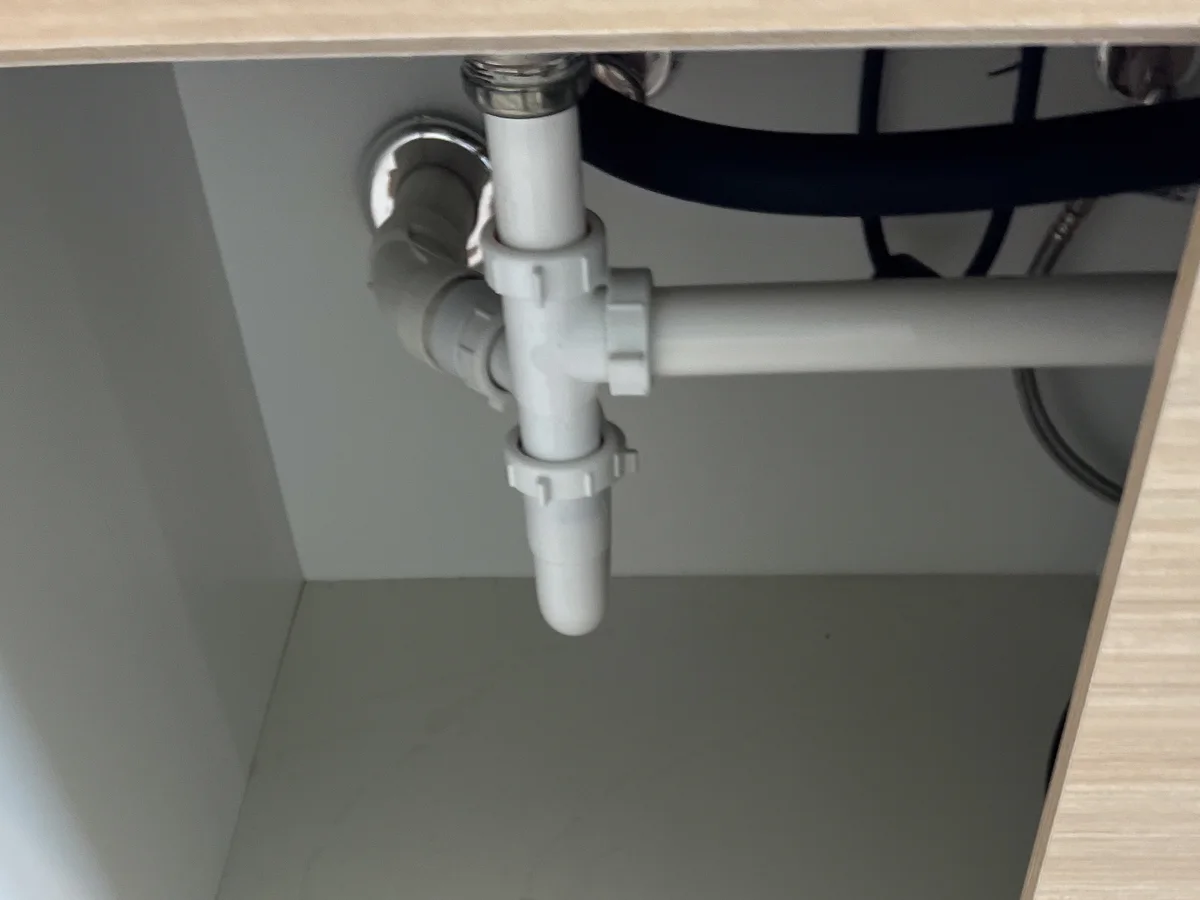 Tubos e sifão brancos em um conjunto de encanamento hidráulico