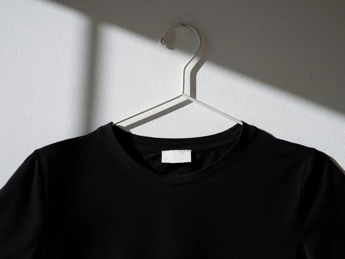 Camiseta preta lisa pendurada em cabide