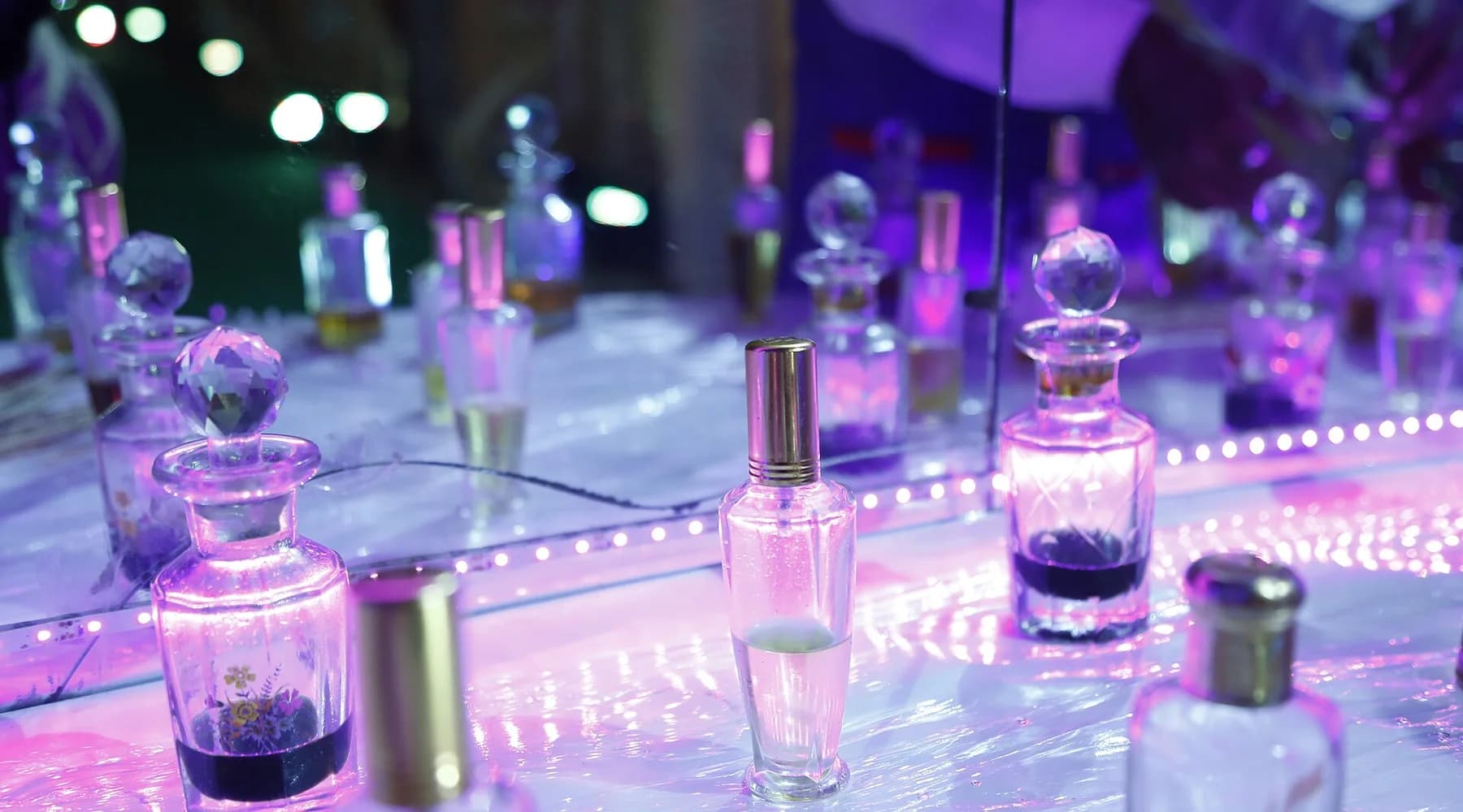 Exposição de frascos de perfume em uma vitrine iluminada, sem marcas legíveis