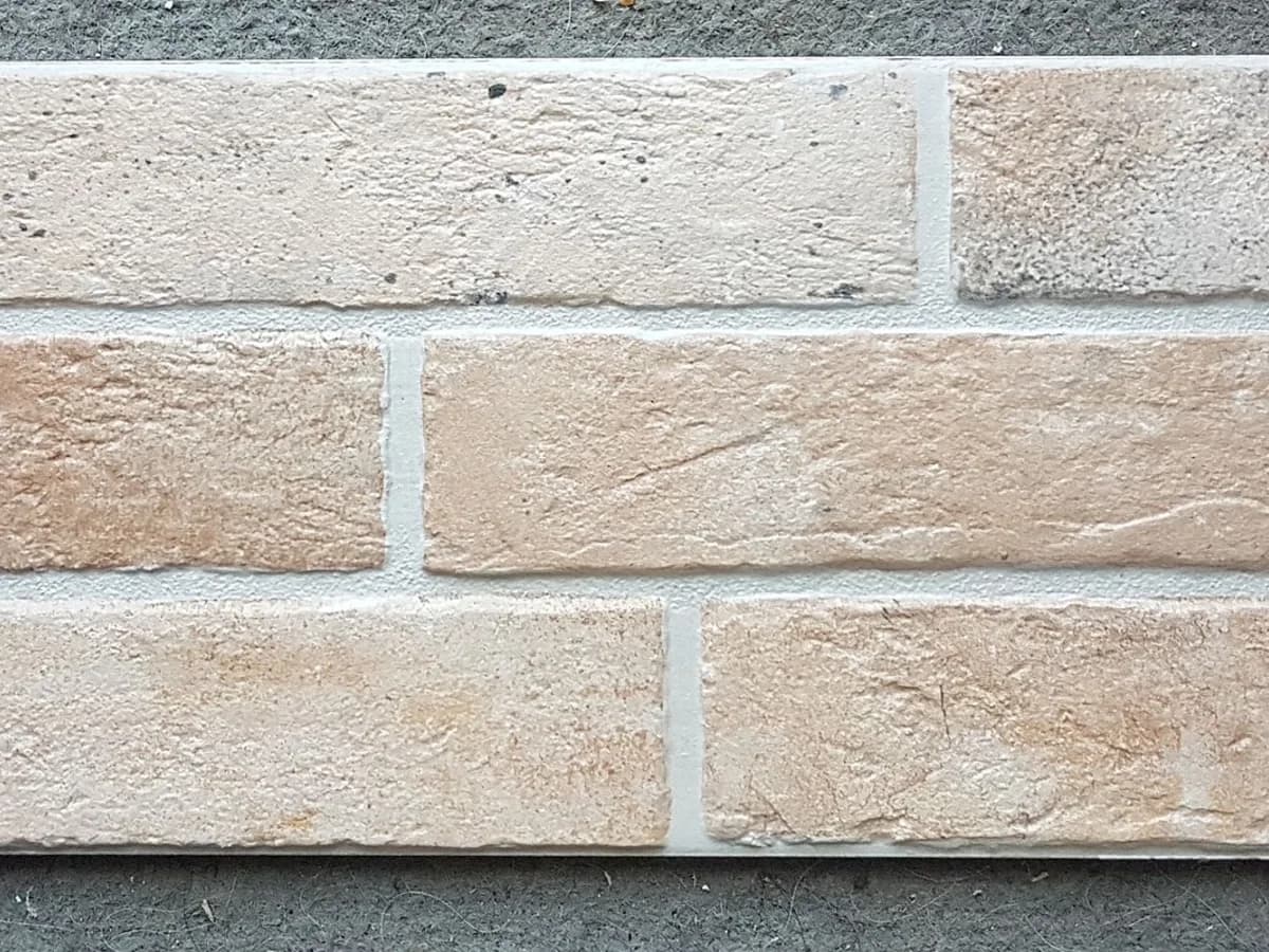 Revestimento cerâmico em placas retangulares com textura de tijolo claro
