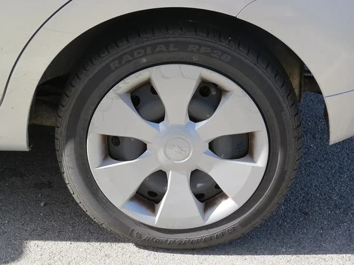 Pneu radial 185/55 R15 instalado em um carro branco