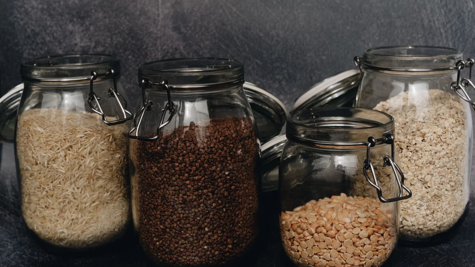Potes de vidro sem rótulos com arroz, trigo-sarraceno, lentilha e aveia