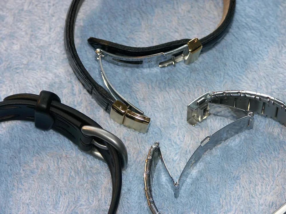 Pulseiras de relógio em apresentações variadas sobre um tecido claro