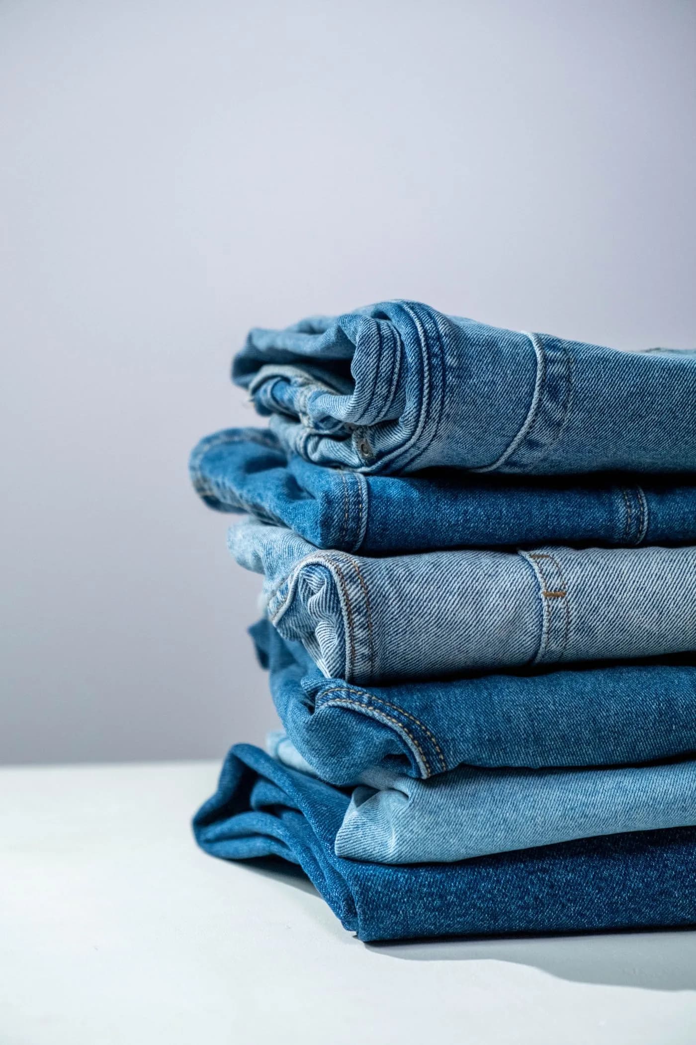 Pilha organizada de calças jeans em diferentes tons de azul