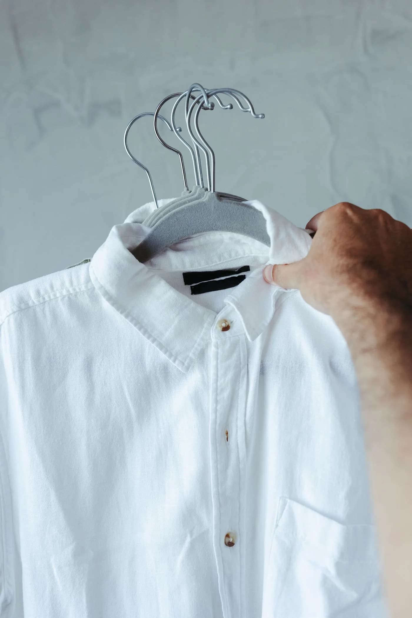 Camisa branca de botões pendurada em cabide