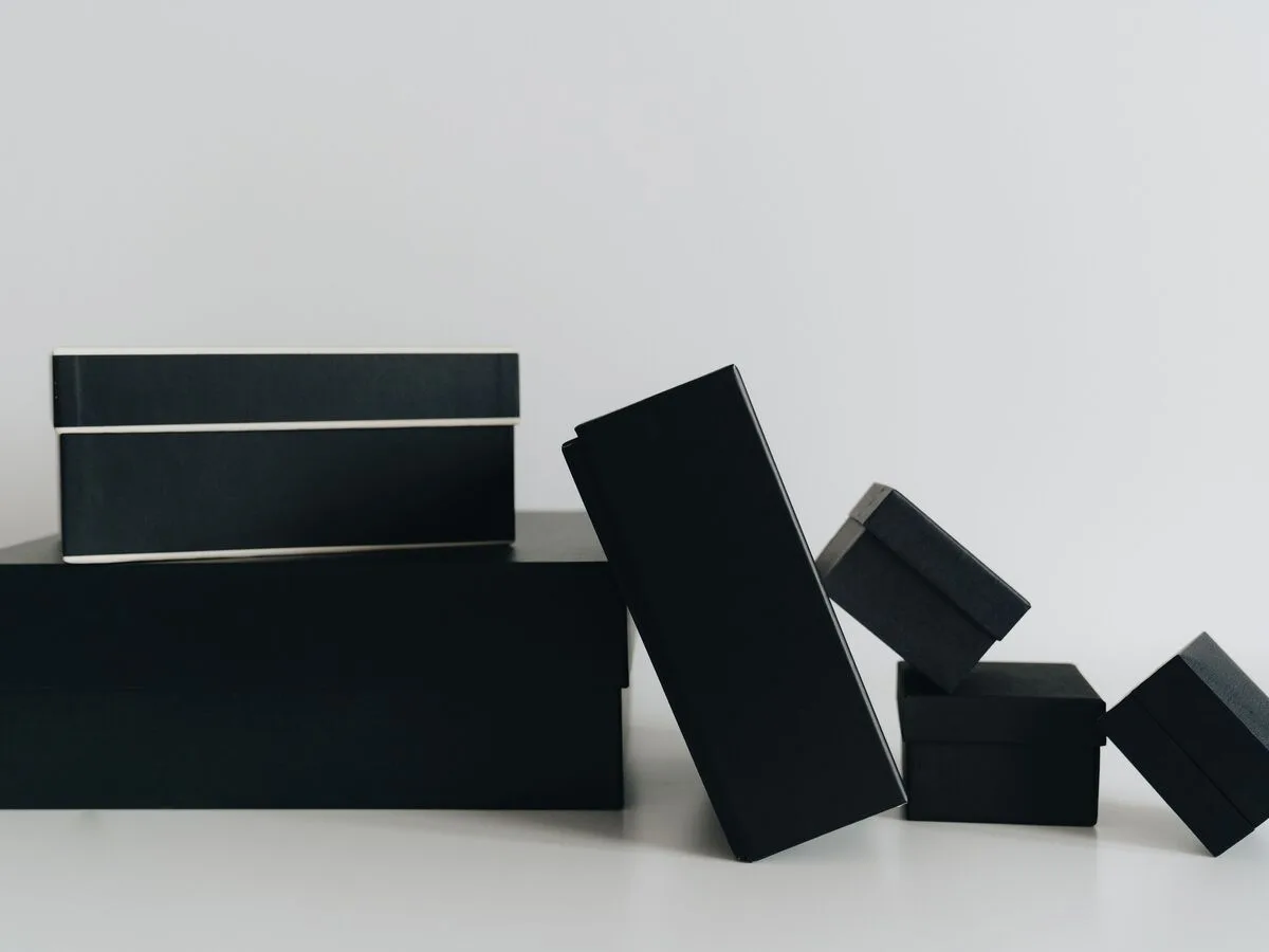 Caixas pretas fechadas em composição abstrata sobre fundo branco
