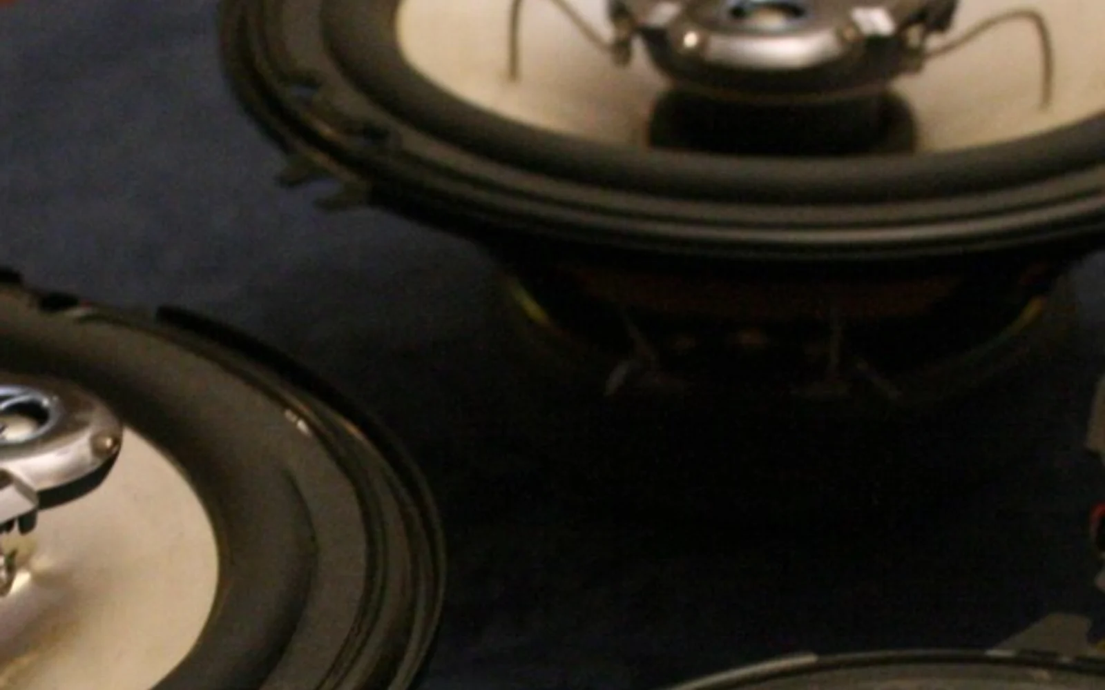 Exposição de alto-falantes automotivos em uma bancada de loja, sem pessoas ou letreiros