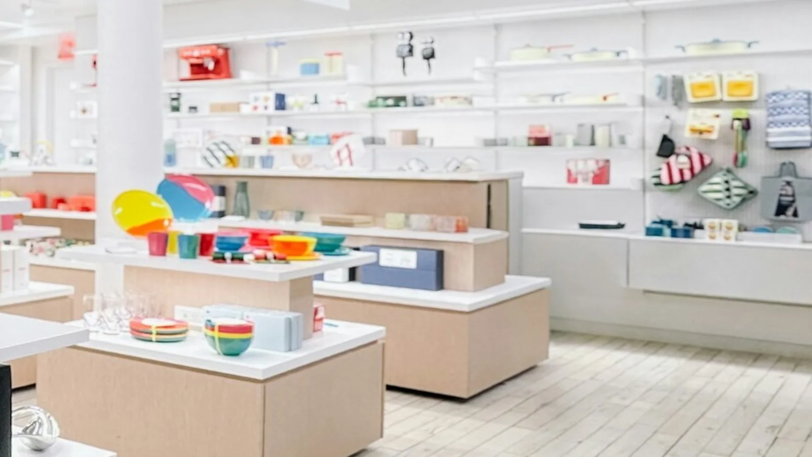 Interior contemporâneo de loja com expositores de objetos coloridos, utilidades e presentes