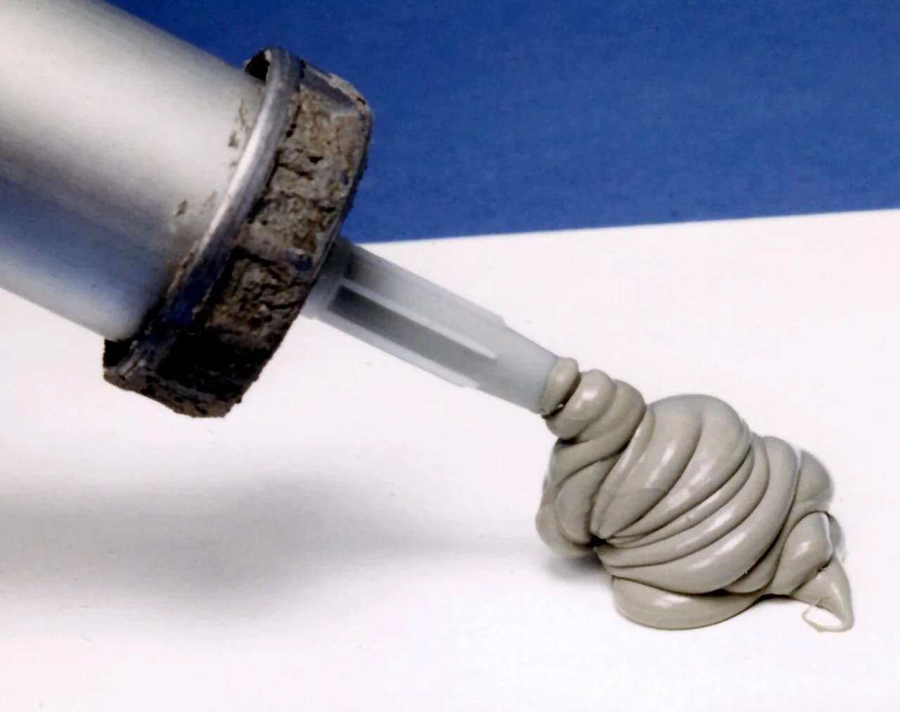 Selante de silicone sendo extrudado, sem rótulo ou marca