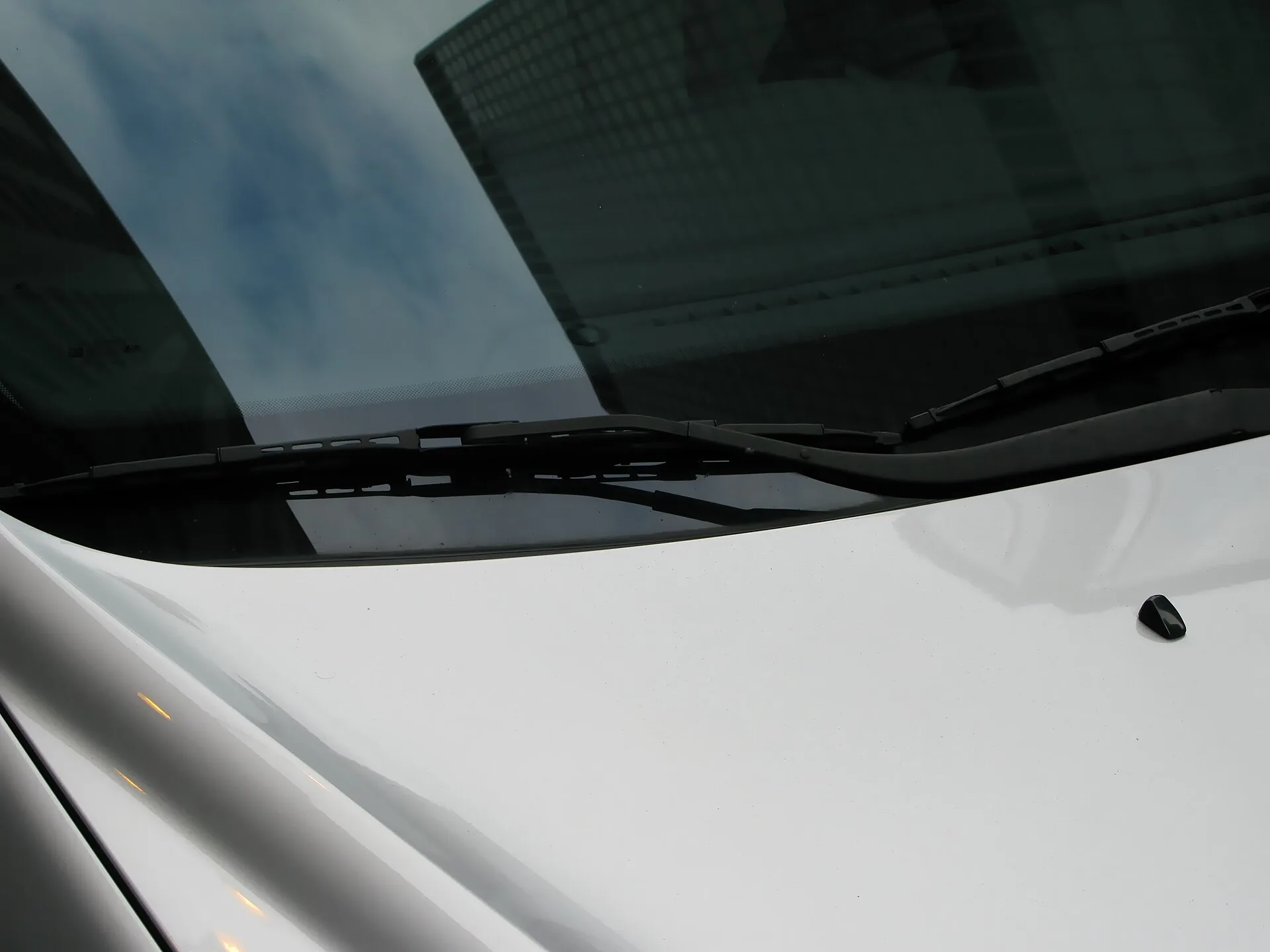 Palhetas limpadoras instaladas no para-brisa de um carro branco