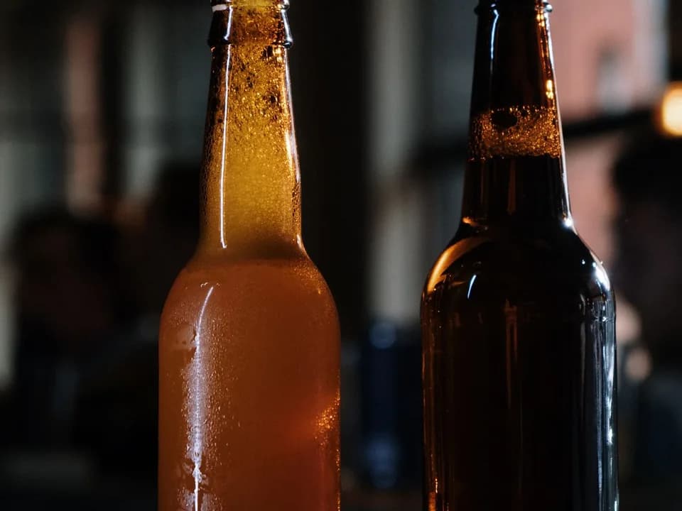 Duas garrafas de cerveja sem rótulo sobre um balcão