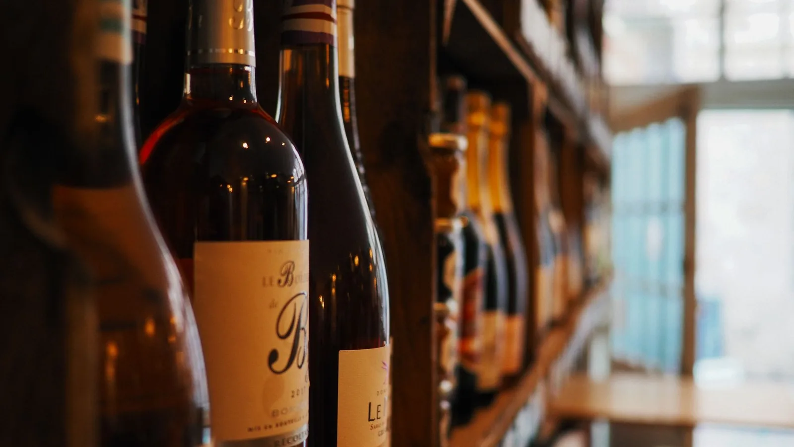 Garrafas de vinho organizadas em prateleiras de uma loja de bebidas