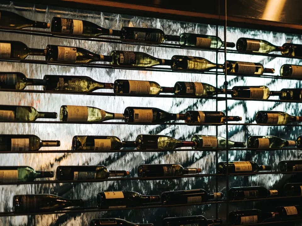 Garrafas de vinho dispostas horizontalmente em uma prateleira