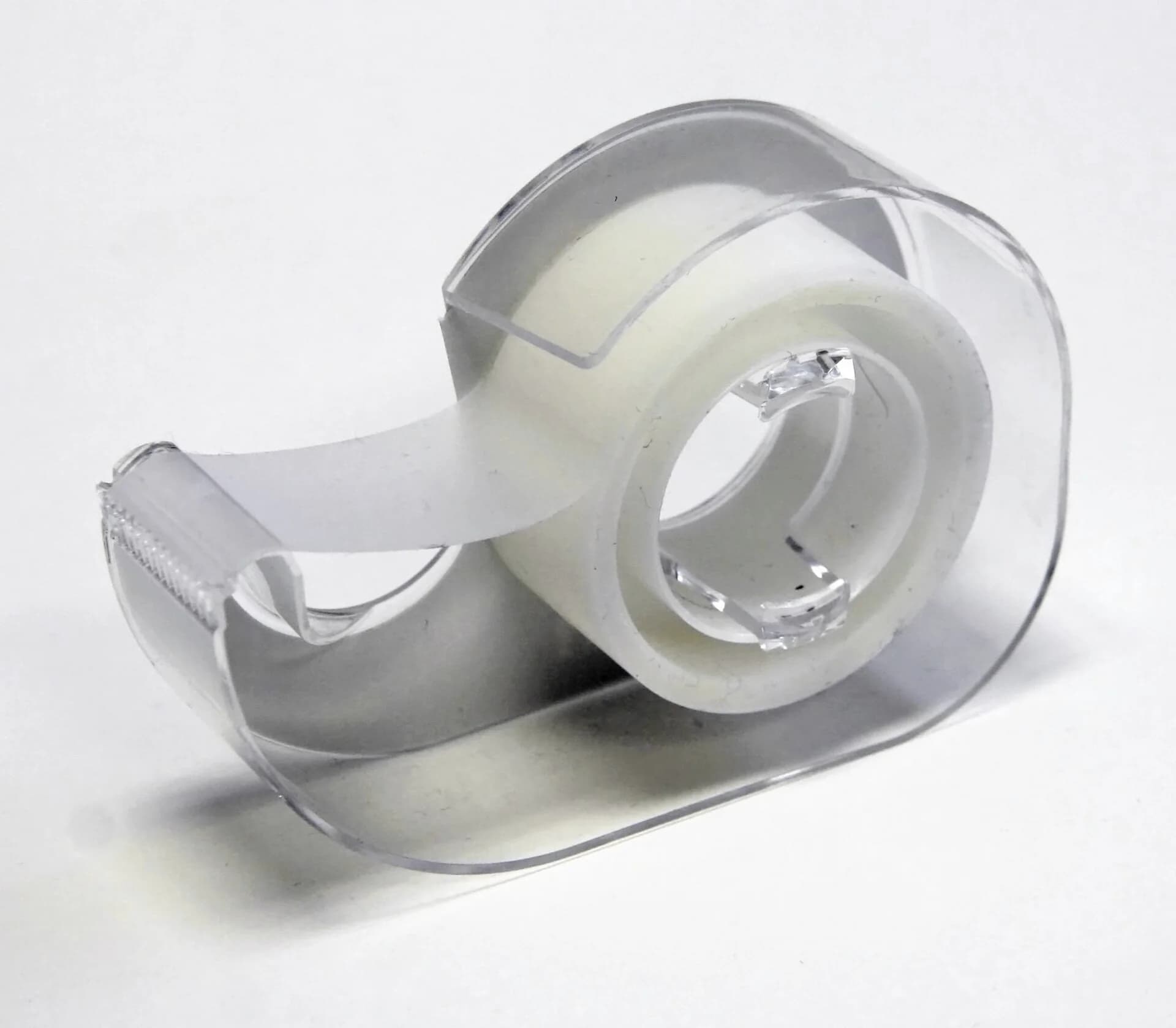 Rolo de fita adesiva transparente em um suporte simples sobre fundo branco