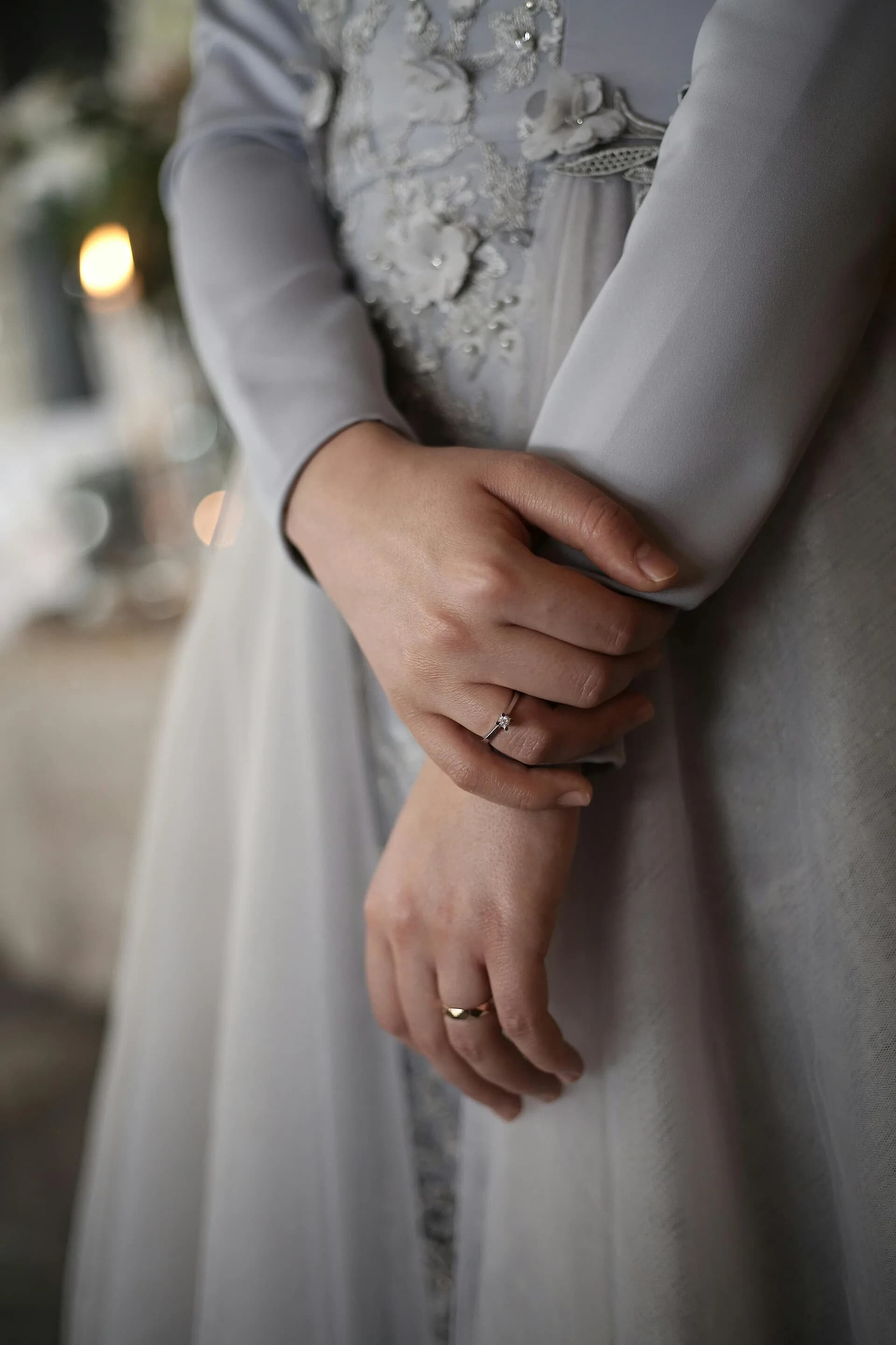Anel de moda usado em uma mão sobre roupa clara