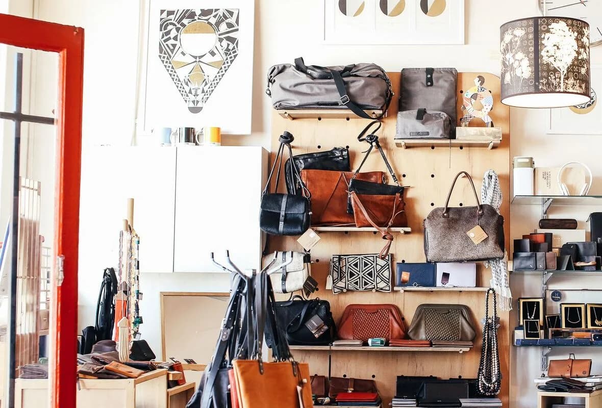 Parede de boutique com bolsas de mão, totes e carteiras expostas