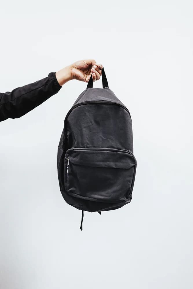 Mochila urbana preta com bolso frontal sobre fundo branco