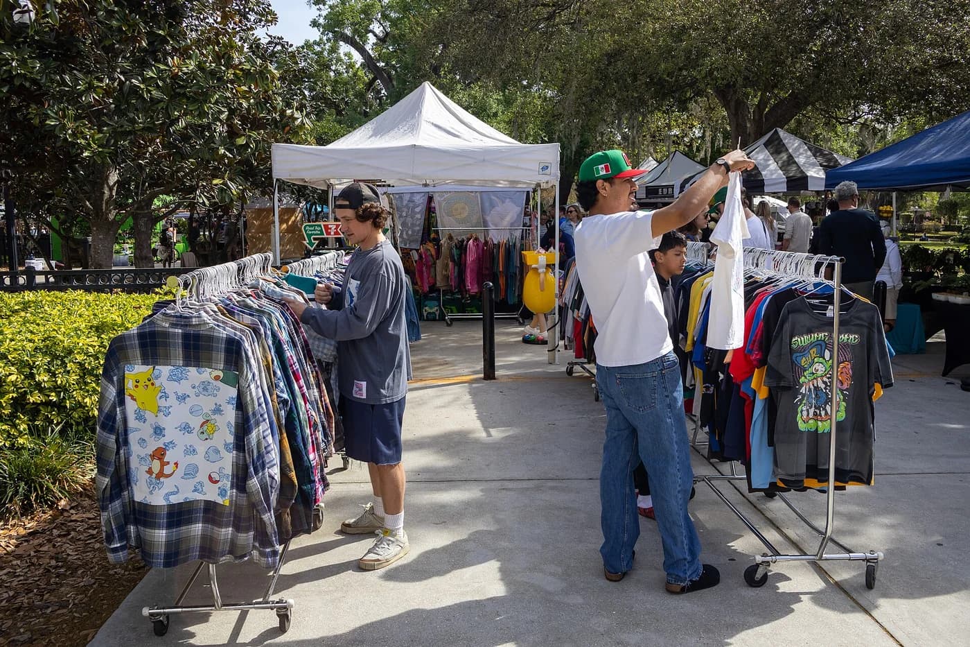 Bancada de feira com roupas usadas variadas expostas para venda