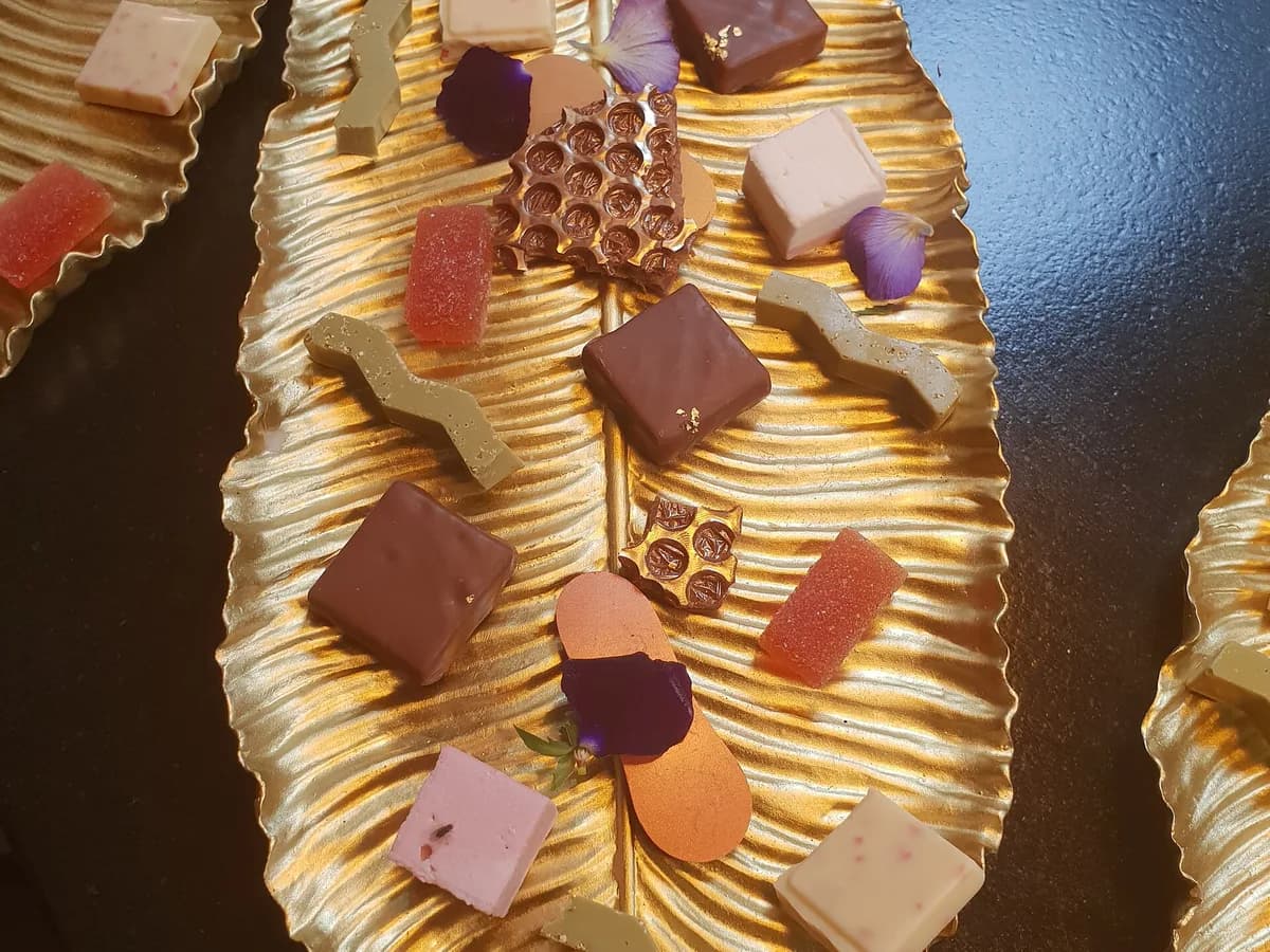 Bombons e chocolates sortidos servidos em uma bandeja dourada