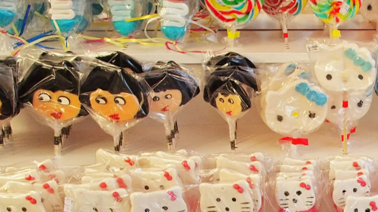 Pirulitos coloridos expostos em uma loja de doces, vistos de perto
