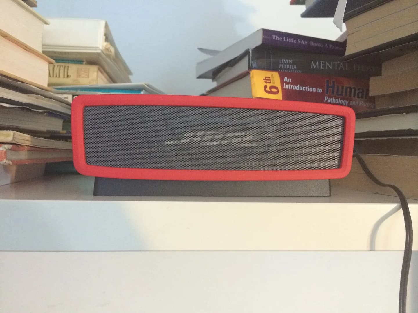 Caixa de som Bluetooth portátil vermelha apoiada em uma mesa
