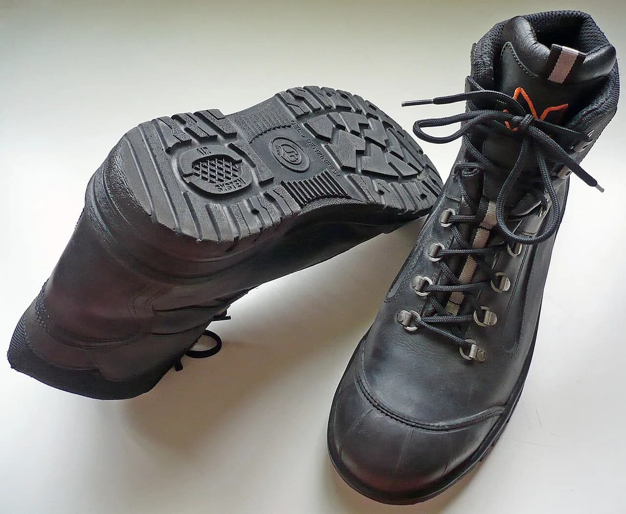 Par de botas de trabalho pretas em uma superfície clara