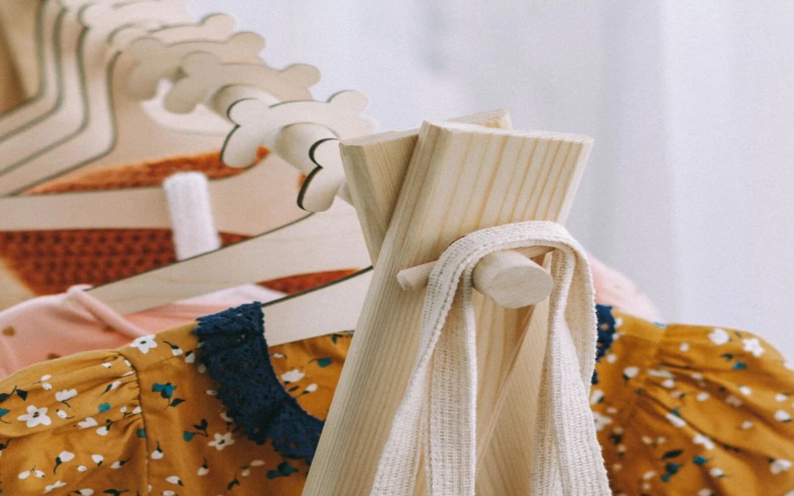 Peças de roupa junto a uma estrutura de madeira, sem pessoas, texto ou marcas visíveis