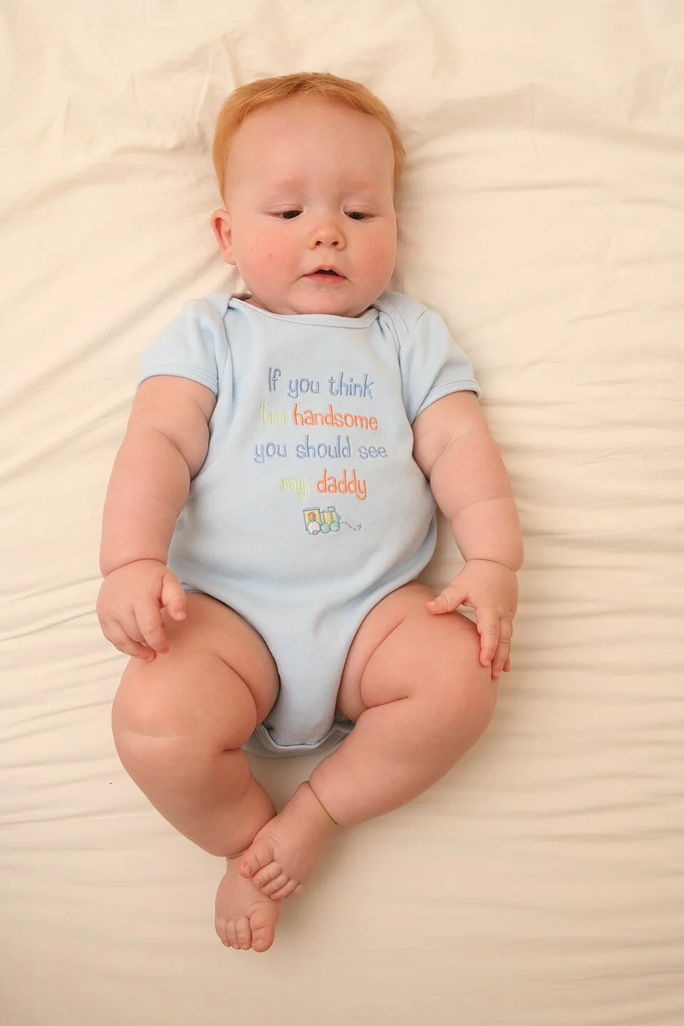Bebê usando body azul claro de mangas curtas, sem marca em destaque