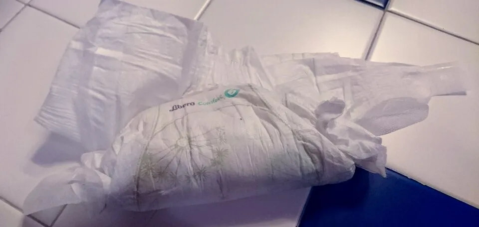 Fraldas descartáveis brancas agrupadas sobre uma superfície clara