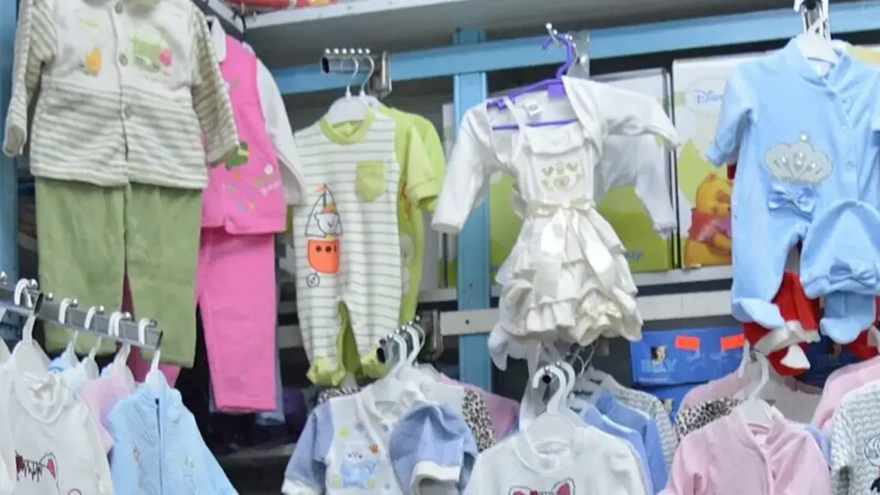Prateleira de loja com roupas e itens de bebê expostos para venda
