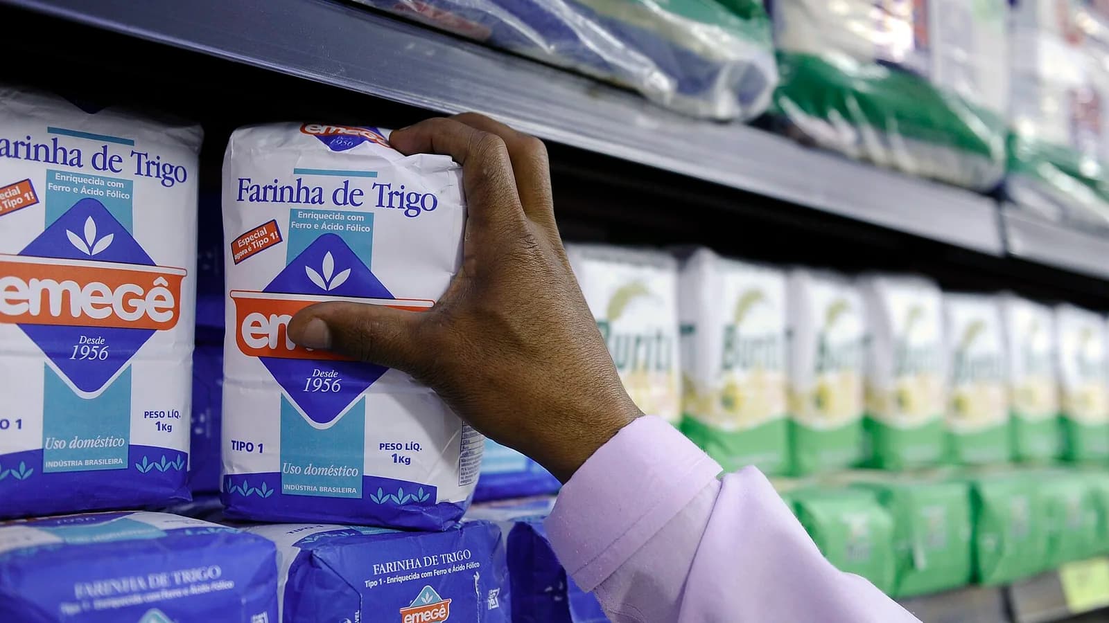 Recorte fechado de uma prateleira abastecida com pacotes brasileiros de farinha de trigo