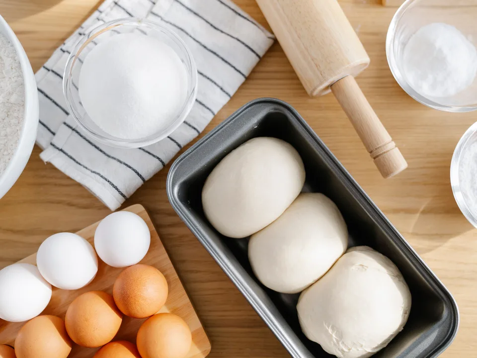 Ingredientes e massas em fermentação sobre bancada de cozinha