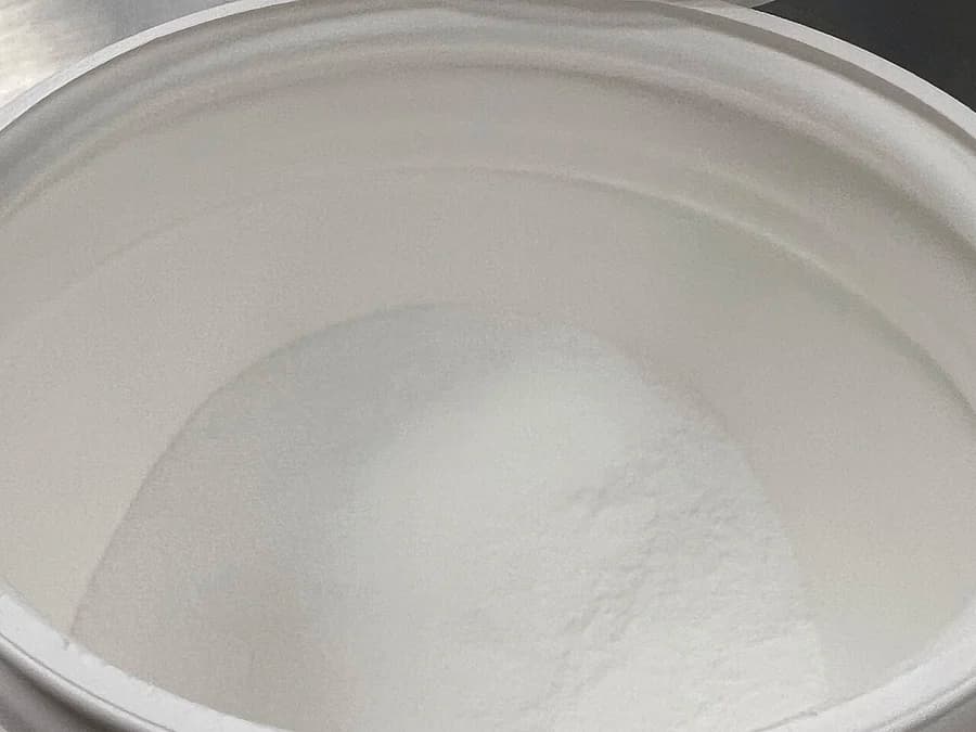 Pote aberto visto de cima com creatina em pó branca
