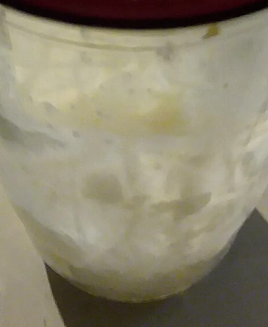 Pote de pasta de amendoim visto em detalhe sem rótulo legível